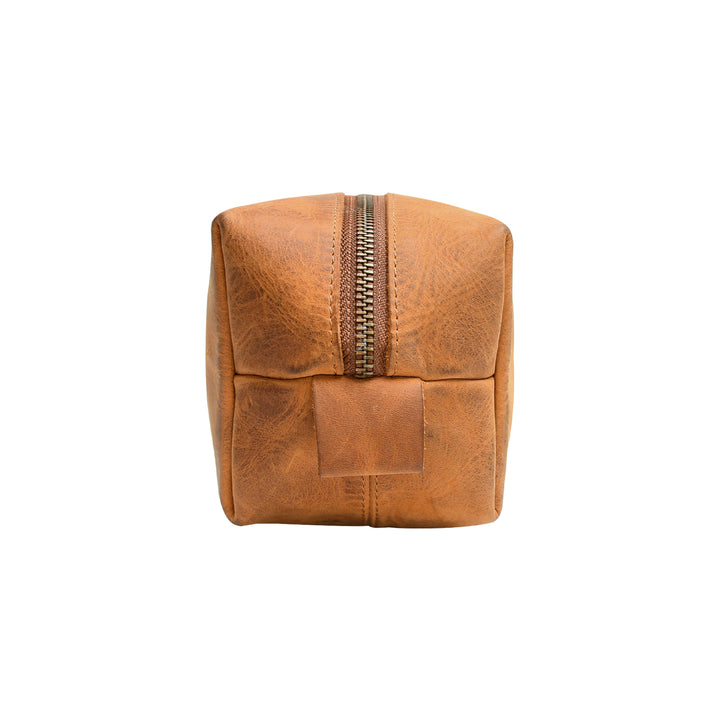 Brown leather toiletry bag with a gold zipper on a white background
