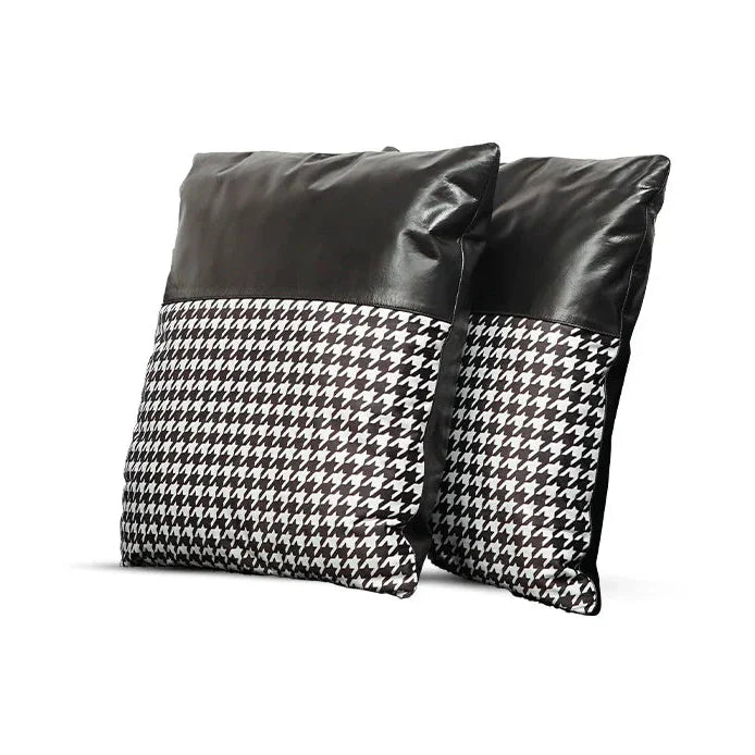 Two pillows with black leather and houndstooth pattern on a white background