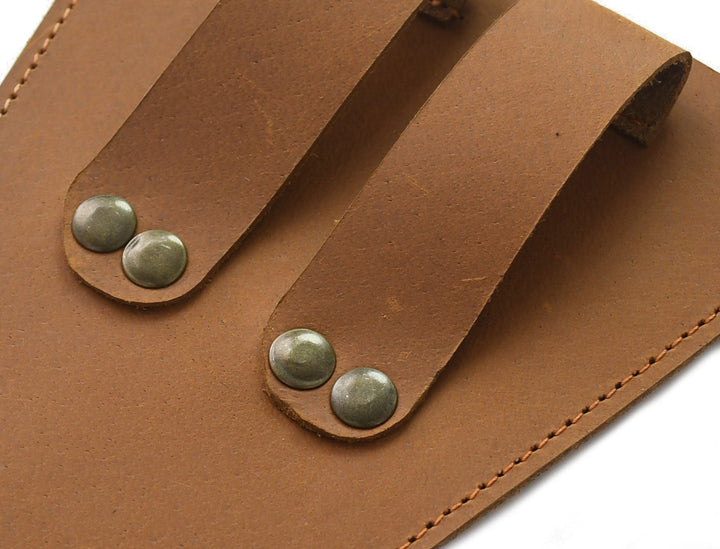 Close-up of a brown leather organizer with metal studs on a white background