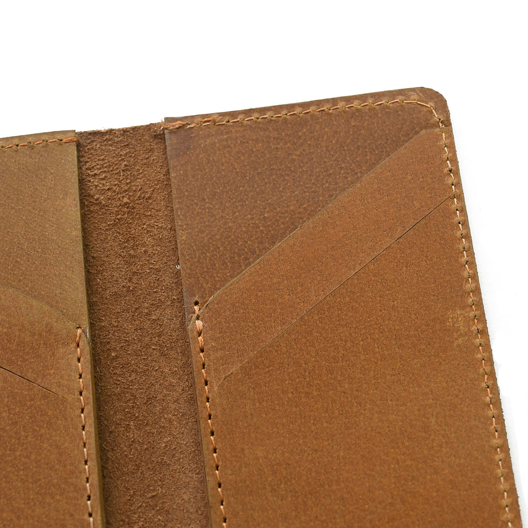 Close-up of a brown leather wallet with visible stitching on a white background