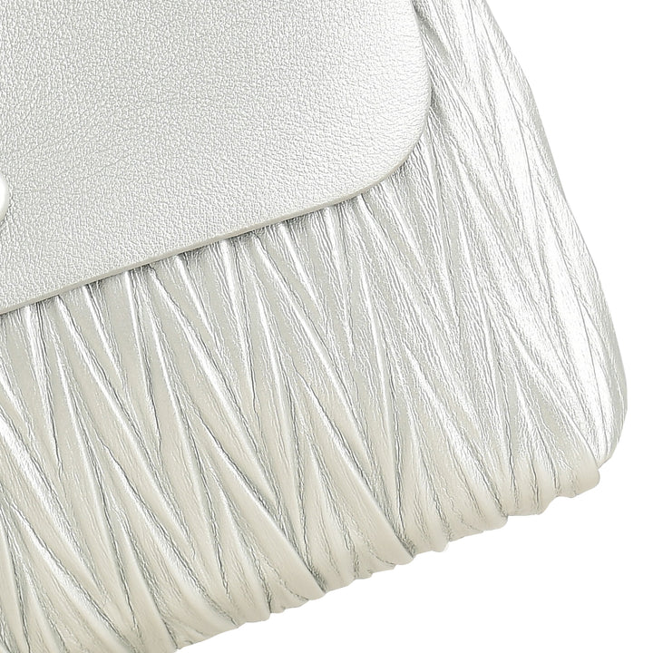 Close-up of a white handbag with textured fabric and metallic flap.