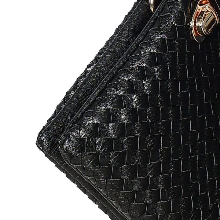 Close-up of a black woven handbag with a gold clasp on a white background