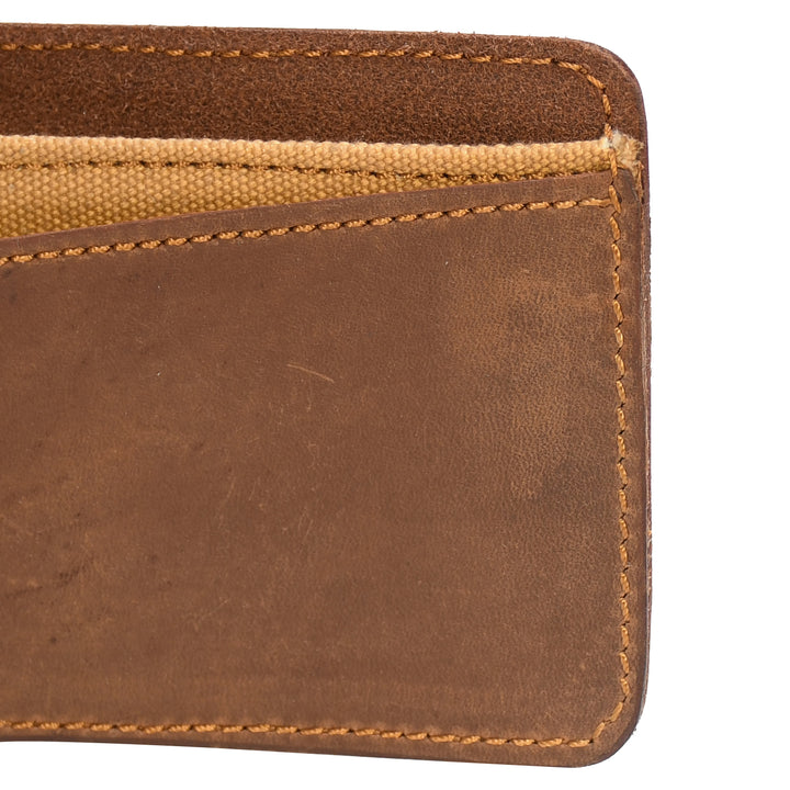 Close-up of a brown leather wallet with beige interior on a white background
