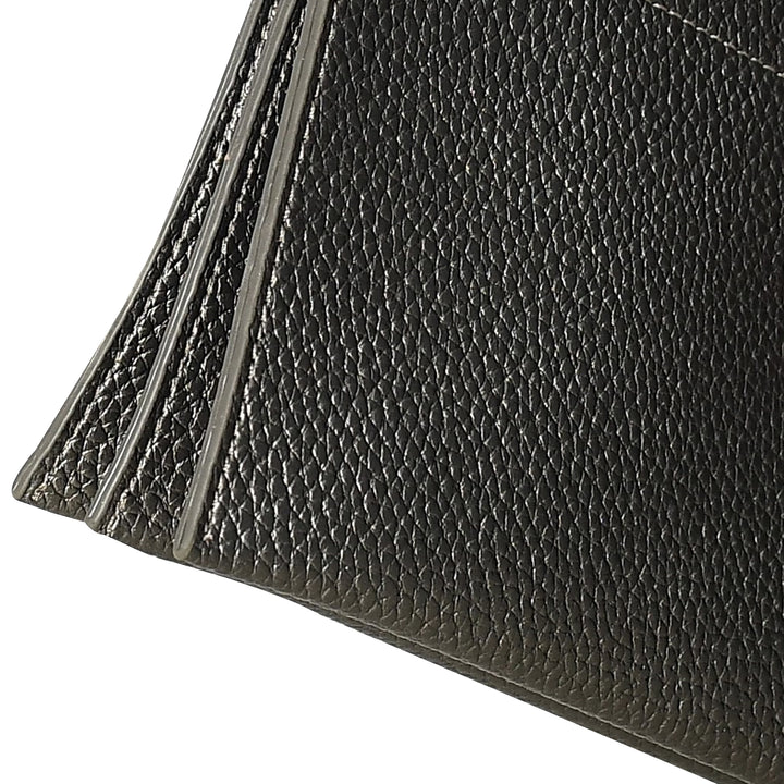 Close-up of a black leather wallet corner on a white background