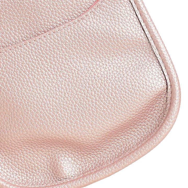 Close-up of a pink leather product with visible texture and stitching.
