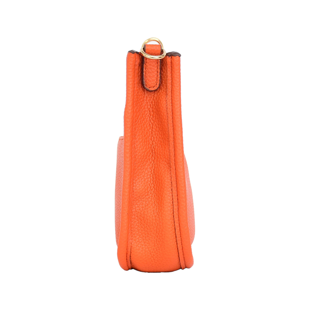 Orange leather bag with a gold ring on a white background