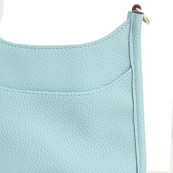 Close-up of a light blue leather bag corner with a gold metal clasp on a white background