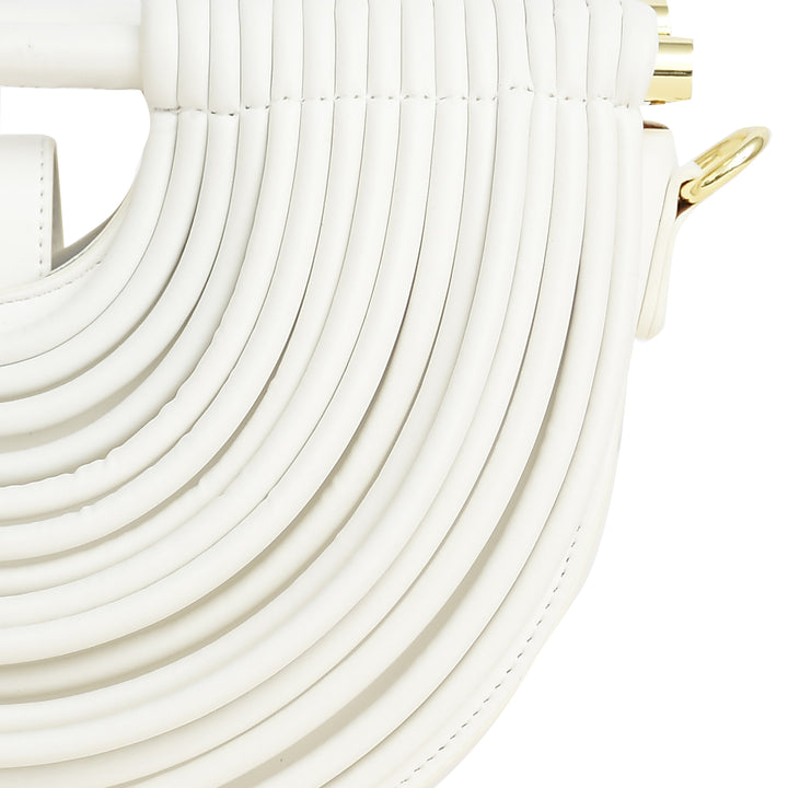 Close-up of a white handbag with gold accents on a light beige background