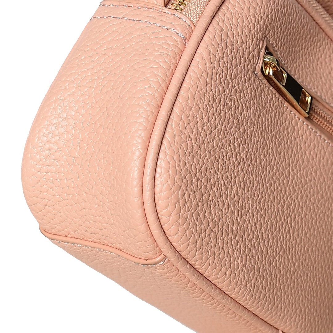 Close-up of a pink handbag with gold zipper details on a white background