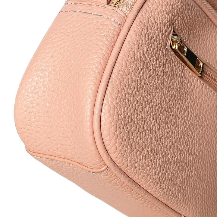 Close-up of a pink handbag with gold zipper details on a white background
