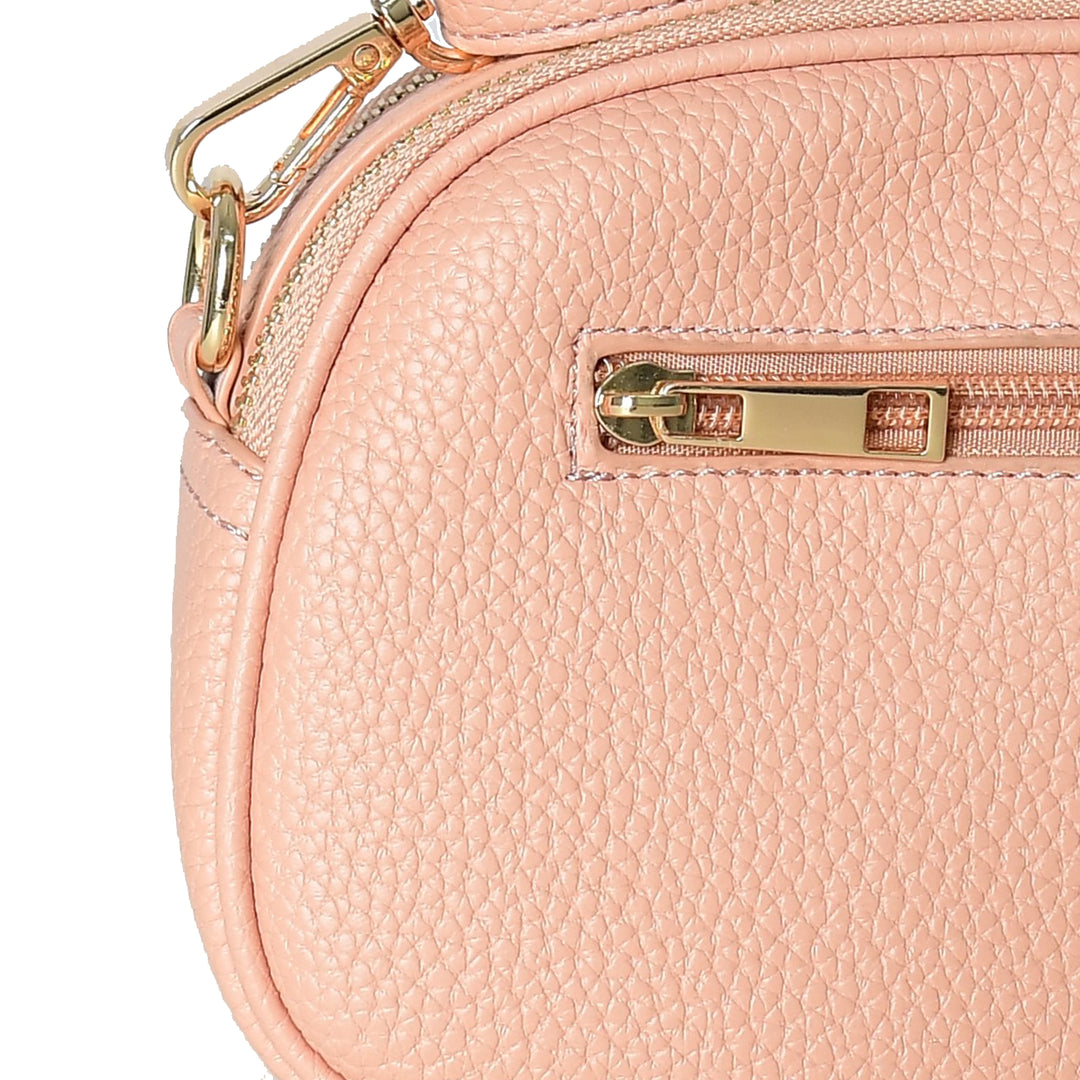 Close-up of a pink handbag with gold zipper and hardware on a white background