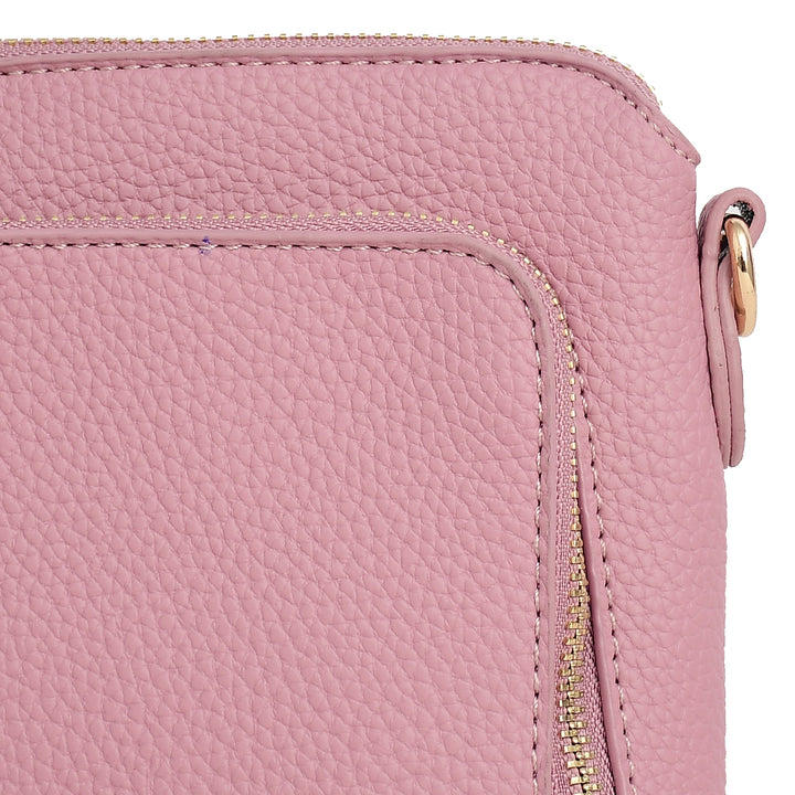 Close-up of a pink leather handbag with a gold zipper.