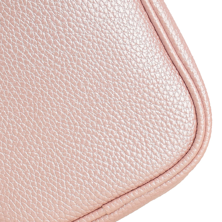 Close-up of a pink leather product with visible texture and stitching.