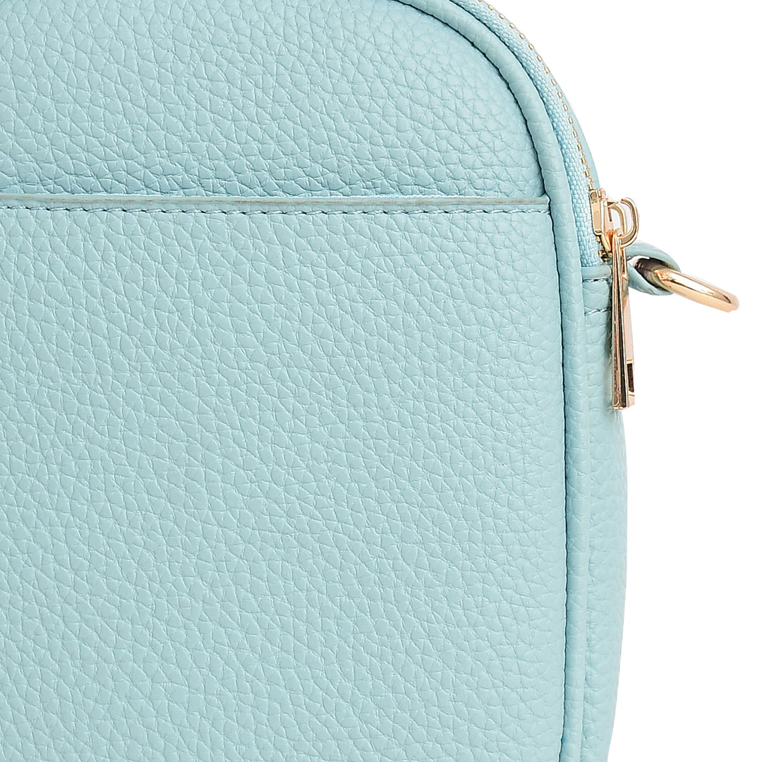 Close-up of a light blue textured bag with a gold zipper.