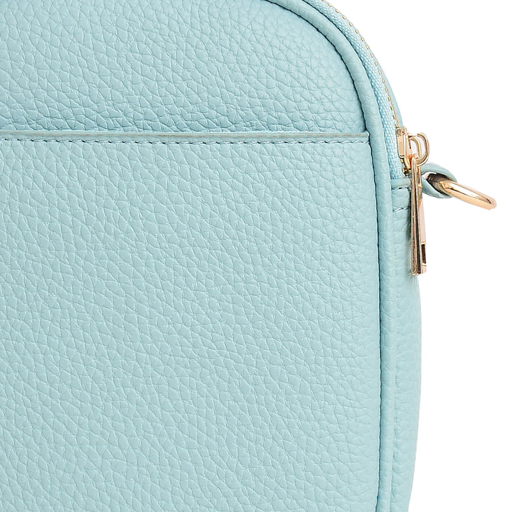 Close-up of a light blue textured bag with a gold zipper.