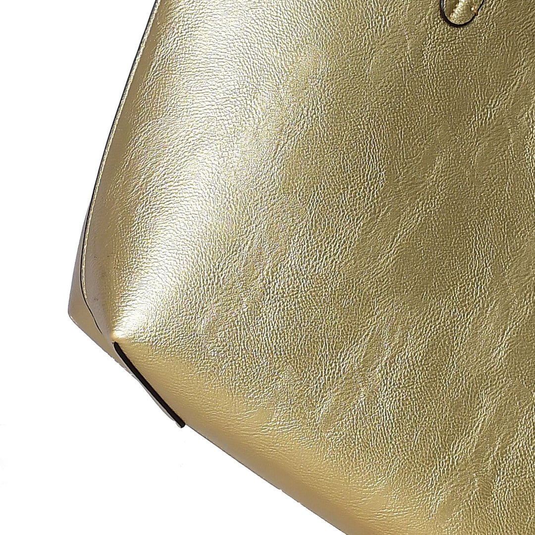 Close-up of a gold handbag with a textured surface.