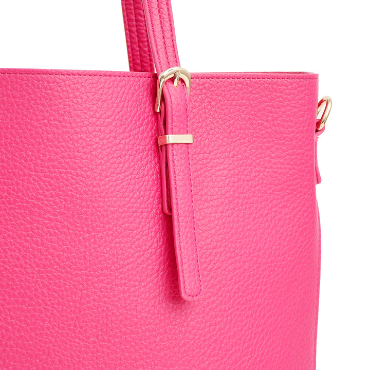 Close-up of a pink handbag with gold accents on a white background