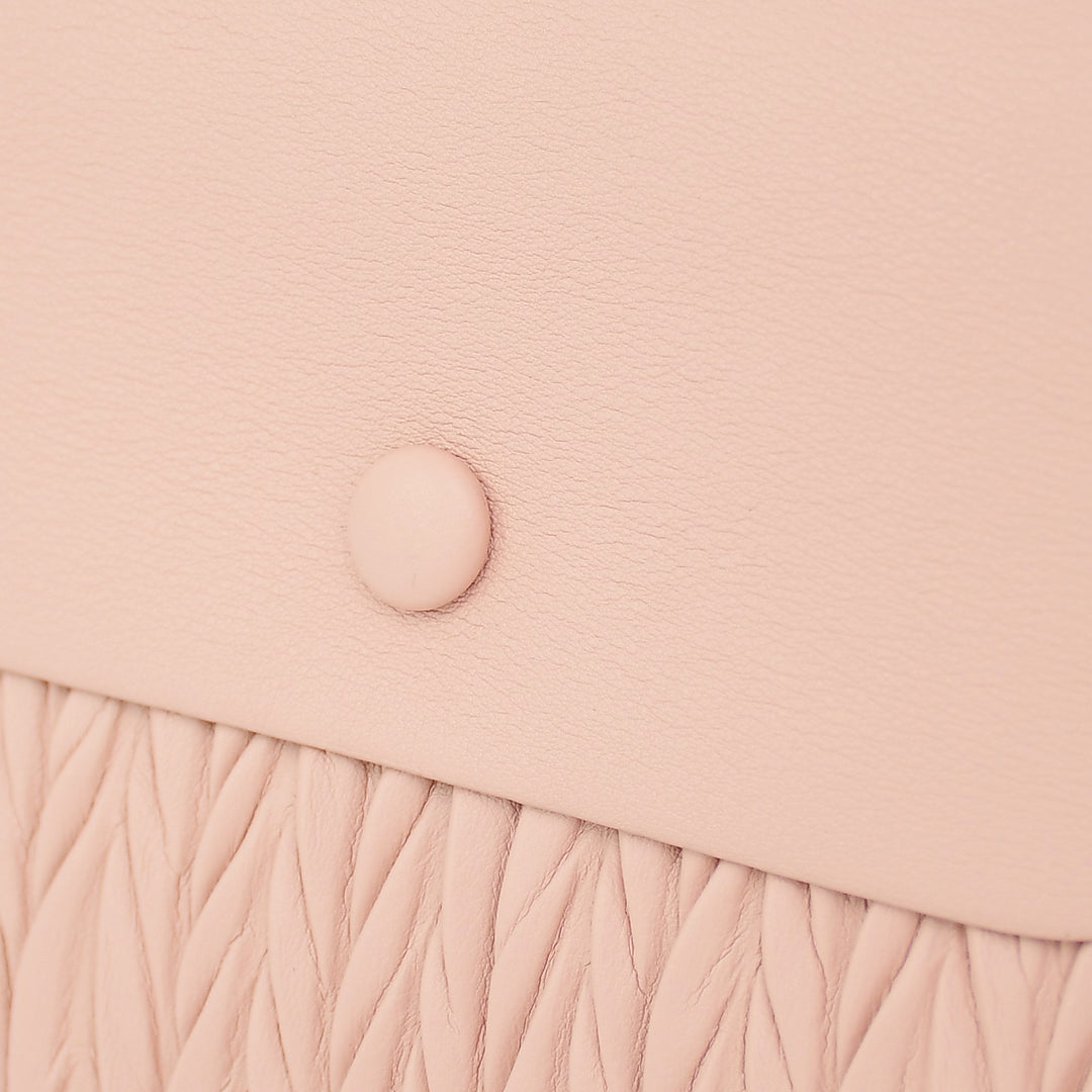 Pink crossbody bag with a textured pattern on a white background