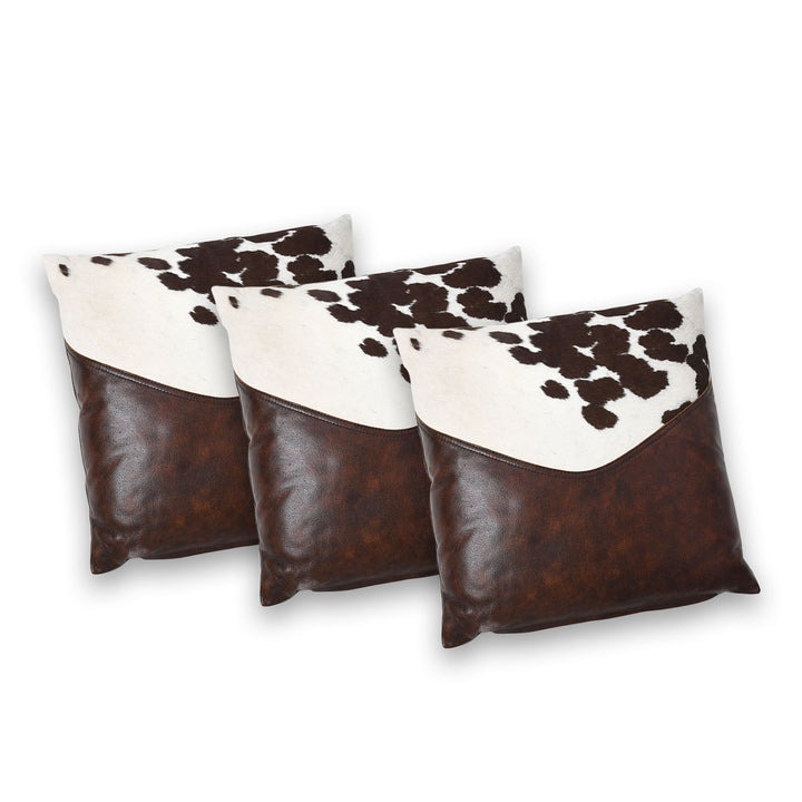 Three cowhide patterned pillows with brown and white