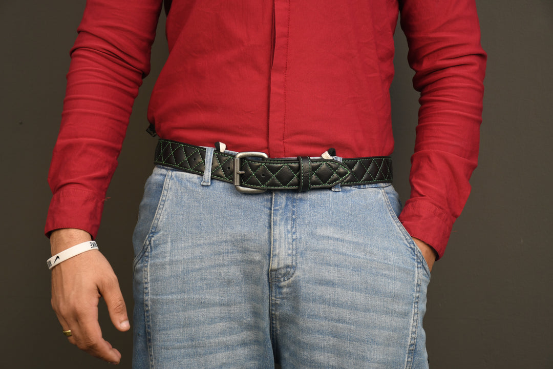 Person wearing a red shirt and blue jeans with a black belt on a plain background