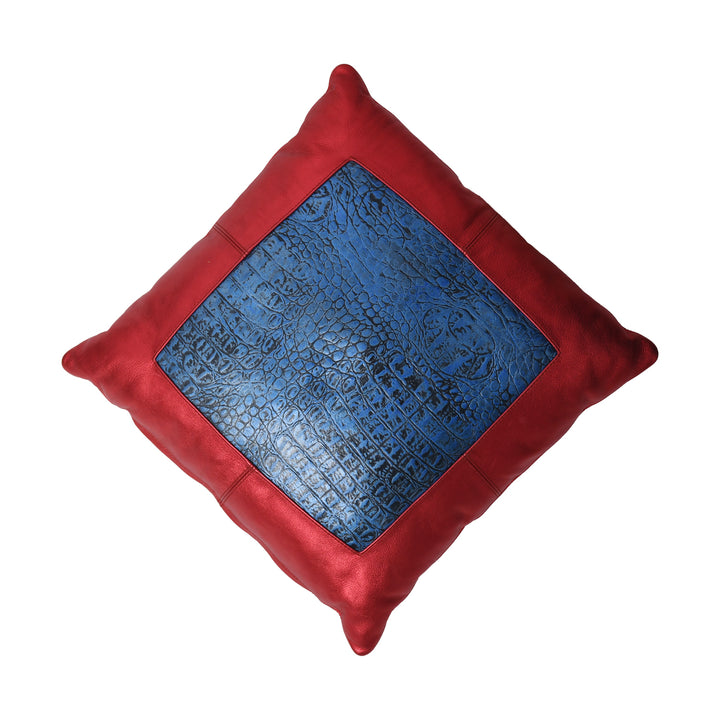 Red pillow with a blue textured square in the center on a white background

