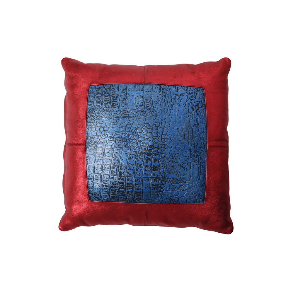Red pillow with a blue textured square in the center on a white background

