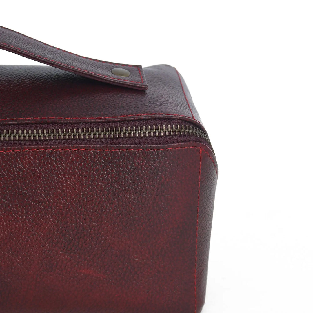 Close-up of a red leather Toiletry bag with a zipper on a white background